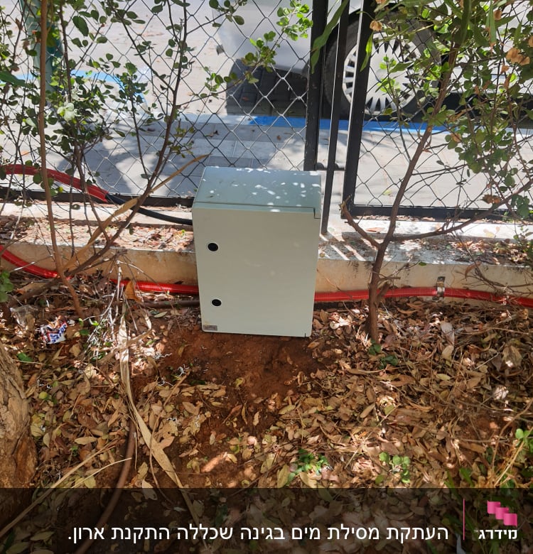 צינור חום על הקרקע ליד קופסה אפורה